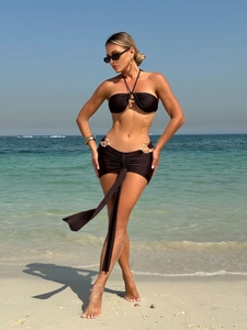 Chic dark brown three-piece bikini set featuring halter top and metallic buckle wrap skirt