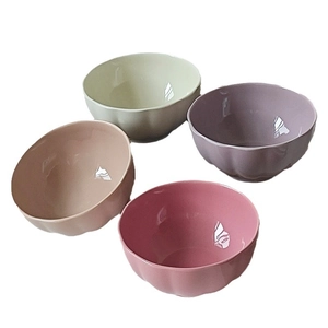 Set of four pastel ceramic rice bowls with scalloped edges in green, purple and pink