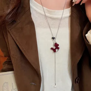 Elegant red flocked horse pendant necklace with zircon and pearl on knit sweater