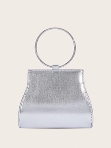 Detail of silver textured clutch featuring a round metal handle and elegant trapezoid shape