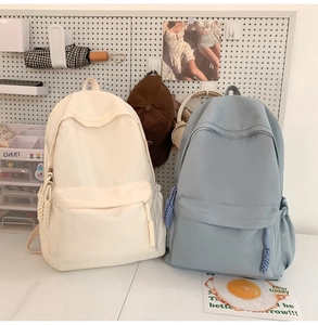 Details minimalistischer Schulrucksäcke in Creme und Blau mit gewebten Zippern