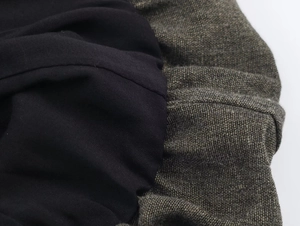 Detail of the stitching between black smooth lining and brown textured fabric on dress