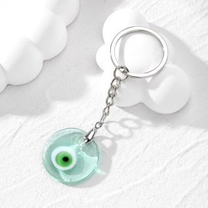 Detailed macro of a green glass evil eye charm on a silver metallic keyring chain