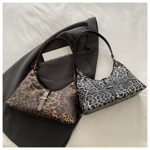 Flachbild von Schultertaschen mit Leopardenmuster in Braun- und Grautönen mit Requisiten