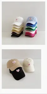 Detailed view of heart embroidered patch on multiple colorful cotton baseball caps