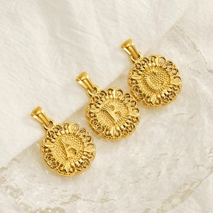 Close-up of gold embossed round initial pendants with letter A B C on textured glass