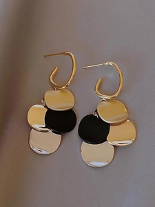 Close-up of vintage gold and black contrast round pendant tassel earrings for women