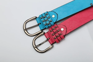Detail of punk style belts with metal studs and D-ring buckles in blue and rose red