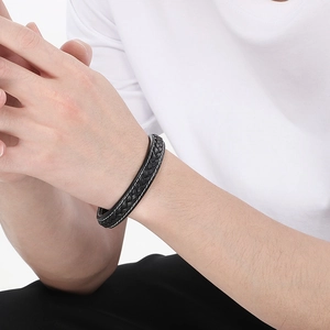 Close-up of double-layer black leather bracelet with white stitching on male wrist