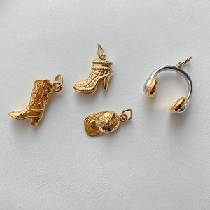 Detailansicht hochwertiger Metallanhänger mit Mini-Cowboystiefeln und Kopfhörern