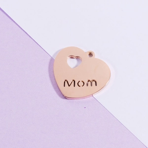 Detail of rose gold heart pendant with Mom cutout design and polished metal finish