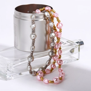 Close-up of silver and pink baroque pearl bracelets with golden accent beads