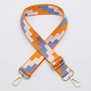 Detail of adjustable bag strap with orange geometric pattern and gold-tone lobster clasps