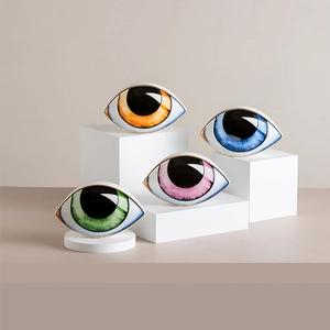 Set of four colorful Evil Eye ceramic ornaments with gold trim on geometric stands