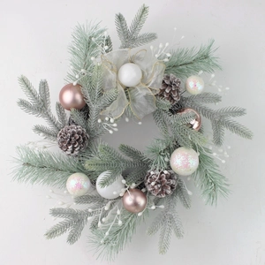 Elegant Christmas pine wreath with frosted needles, pinecones and rose gold ornaments