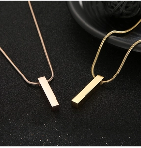 Detail of rose gold and gold minimalist 3D pillar pendants on snake bone chains