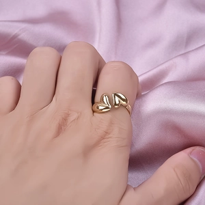 Minimalist double heart open ring in gold stainless steel worn on a model's hand