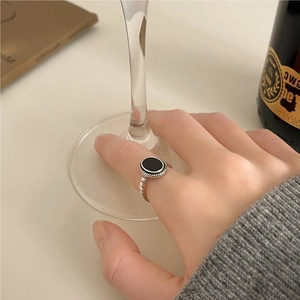 Close-up of vintage silver ring with black agate worn while holding a wine glass