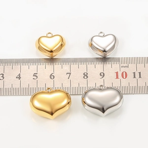 Macro view showing 15mm and 25mm polished heart pendants in gold and silver colors