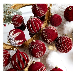 Detailed view of red velvet Christmas balls with pearls and embroidery on a white blanket