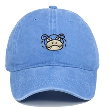 Detail of embroidered cartoon character on vintage washed cotton blue baseball cap
