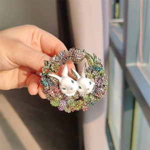 Detail of vintage rabbit brooch featuring colorful rhinestones and white enamel finish