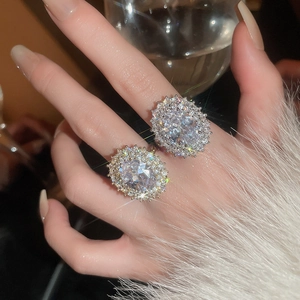 Detailed view of two luxury silver rings with pave-set oval cubic zirconia on hand