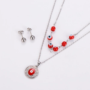 Detail of silver layered necklace with red evil eye charms and matching ball stud earrings