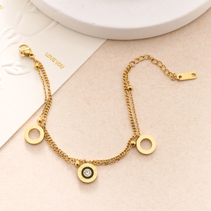 Detailed macro of gold double-layer chain bracelet with zircon and Roman numeral charms