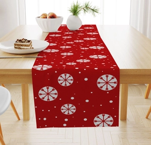 Close-up of red Christmas linen table runner with white snowflake patterns on wood