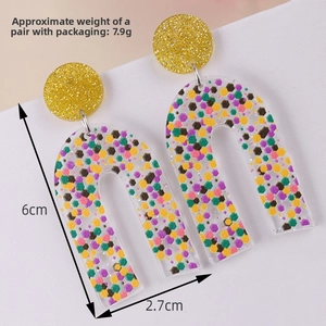 Detail showing dimension and colorful sequins inside arc-shaped acrylic earrings