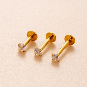 Three gold labret studs with round clear cubic zirconia stones in a macro detail shot