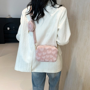 Pink heart-patterned crossbody bag with wide strap and matching round coin purse