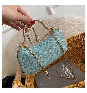 Close-up of light blue glitter clutch bag with gold handle and sparkling clasp