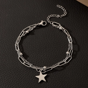 Detail of silver double-layered chain bracelet with star pendant on black leather