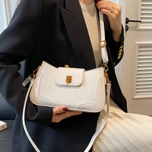 Detail of white PU leather shoulder bag with gold metal lock and adjustable strap