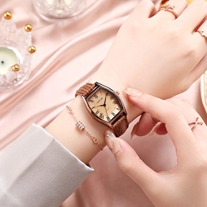 Montre vintage pour femme avec cadran rectangulaire et bracelet en cuir marron sur soie rose