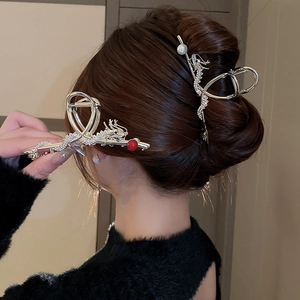 Detail of silver dragon hair claw with pearls and crystals on styled hair