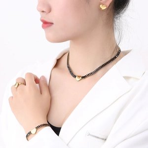 Parure de bijoux vintage dorée avec pendentifs cœur et zircon noir sur un mannequin