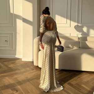 Detail eines eleganten rückenfreien Kleides in Creme mit schwarzen Punkten und Passform