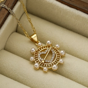 Elegante collana dorata con ciondolo a cuore e perle in una scatola di velluto beige
