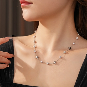 Close-up of a silver flower necklace with pearls and zircon crystals on a model's neck