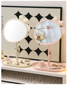 Detail of cute desktop makeup mirror with bow decor and heart pearl pendant tray