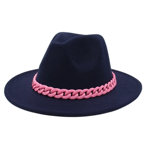 Detail of navy blue fedora with a bold pink chunky plastic chain accent band
