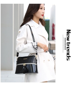 Fashionable black crocodile pattern tote bag with gold hardware and tassel detail