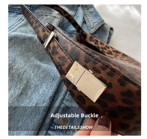 Detail of leopard print bag featuring a polished gold buckle against denim background
