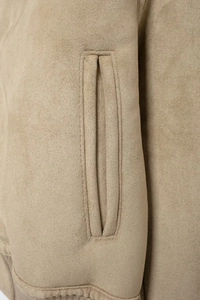 Détail de la veste en daim kaki montrant les coutures de précision et la poche latérale