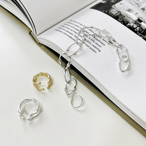 Detail der silbernen Kette im Lava-Stil und geschmolzenen Ringe auf Modemagazin