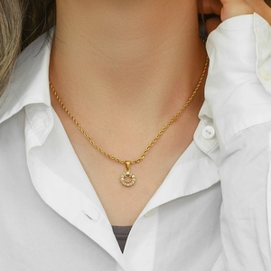 Detail of 18K gold-plated twist chain necklace with sparkling zircon smiley face pendant
