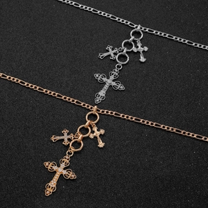 Detail of silver and gold Figaro chain necklaces with crystal-encrusted cross pendants